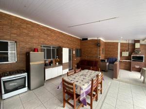 una cucina e una sala da pranzo con tavolo e frigorifero di Casa com Piscina Bertioga a Bertioga