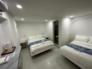um quarto de hotel com duas camas e um espelho em Luckytito Anilao Resort em Mabini