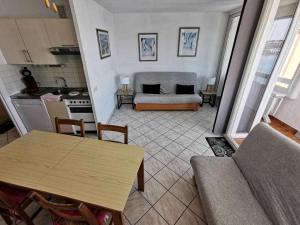 een keuken en een woonkamer met een tafel en een bank bij Résidence TERRASSES DE LA MEDITERRANEE 1 - 2 Pièces pour 5 Personnes 54 in Port Leucate