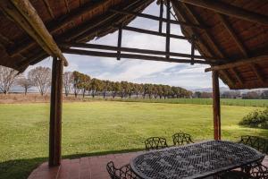 a patio with a table and chairs and a field at Ardmore Guest Farm in Champagne Valley