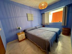 een blauwe slaapkamer met 2 bedden en een raam bij Apolo XI Calpe vistas al mar in Calpe
