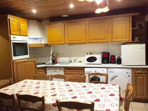 a kitchen with a table and a kitchen with a table and chairs at Chalet Les Lupins - 3 Pièces pour 6 Personnes 04 in Valloire