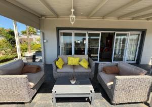 a patio with two couches and a coffee table at Sir Roys at the Sea in Port Elizabeth