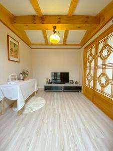 un grand salon avec une table et une télévision dans l'établissement Hanok guesthouse Ann, 