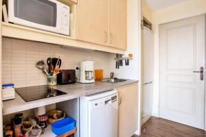 kuchnia ze zlewem i kuchenką mikrofalową w obiekcie Résidence Les Parcs de Grimaud - maeva Home - Appartement 2 pièces 4 personnes Prestige MAE-2246 w mieście Grimaud