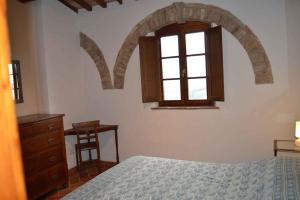 a bedroom with a bed and a window and a dresser at Apartment in Asciano/Toskana 24106 in Asciano