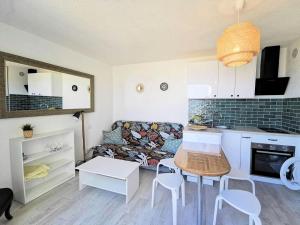 Il dispose d'une cuisine et d'un salon avec un canapé et une table. dans l'établissement Résidence Les Nefs Des Sables - APPT T2 CAB OU MEZZ 6 couchages PORT LEUCATE. Réf: 2NEF_45K4 MAE-5304, à Port-Leucate 16 autres photos