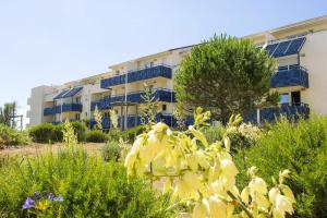 a yellow plant in front of a building at Résidence Bleu Marine - maeva Home - Appartement 2 pièces 4 personnes Confort MAE-2510 in Lacanau +8 photos