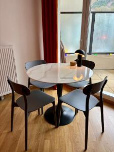 une table, deux chaises, une table et des chaises dans l'établissement Appartement proche centre parking & terrasse, à Besançon
