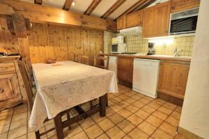 uma cozinha com uma mesa com uma toalha de mesa em Résidence La Beguette - 2 Pièces pour 6 Personnes 54 em Notre-Dame-de-Bellecombe