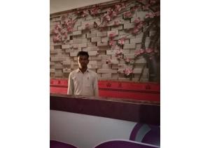 een man voor een toonbank met roze bloemen bij Hotel Ashray Angul in Angul