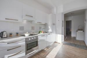 a kitchen with white appliances and a wooden floor at La Finestra di Laura - Happy Rentals in Laveno-Mombello