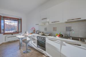 een keuken met witte apparatuur en een tafel. bij La Finestra di Laura - Happy Rentals in Laveno-Mombello