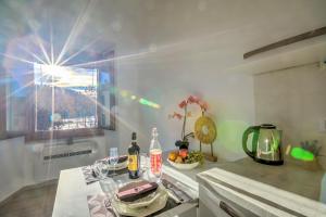 een keuken met een tafel met flessen en een raam bij La Finestra di Laura - Happy Rentals in Laveno-Mombello