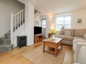 a living room with a couch and a fireplace at Bell Cottage in Penzance