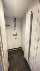 a bathroom with a shower with white tiled walls at KUST4 huis met Sauna in Egmond aan Zee