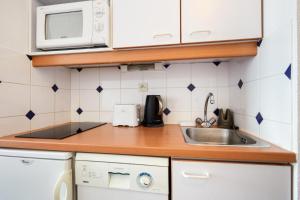 una cocina con fregadero y microondas en Résidence Port Guillaume - maeva Home - Studio 2 personnes Sélection MAE-3802, en Dives-sur-Mer 9 fotos más