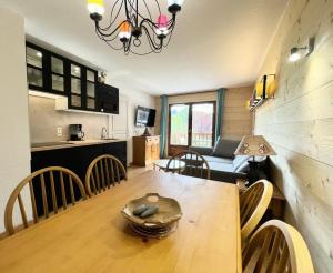 a kitchen and a dining room with a table and chairs at Les Chalets Des Evettes - 3 Pièces pour 6 Personnes 44 in Notre-Dame-de-Bellecombe