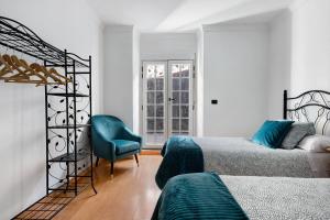 a bedroom with two beds and a blue chair at La Planta Vieja in La Orotava