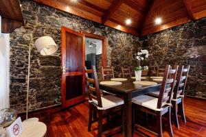 un comedor con paredes de piedra, mesa y sillas en La Planta Vieja en La Orotava