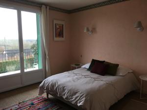 ein Schlafzimmer mit einem Bett und einem großen Fenster in der Unterkunft chez Anne in Tanlay