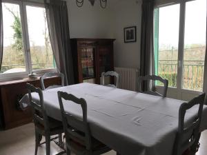 ein Esszimmer mit einem weißen Tisch und Stühlen in der Unterkunft chez Anne in Tanlay
