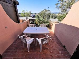 een tafel en stoelen op een bakstenen patio bij Résidence MAISONS DE LA MER 2 - 2 Pièces pour 4 Personnes 94 in Port Leucate