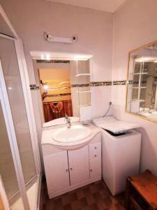 een witte badkamer met een wastafel en een spiegel bij Résidence MAISONS DE LA MER 2 - 2 Pièces pour 4 Personnes 94 in Port Leucate