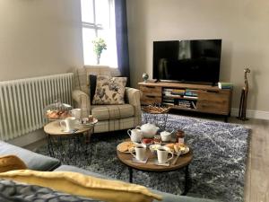 a living room with two coffee tables and a tv at Charming Coastal Getaway - Pembroke in Pembrokeshire
