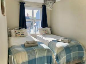 two twin beds in a room with a window at Charming Coastal Getaway - Pembroke in Pembrokeshire