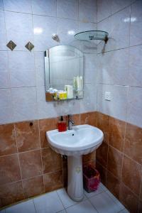 uma casa de banho com um lavatório e um espelho em Malik Dijlah Hotel em Bagdá