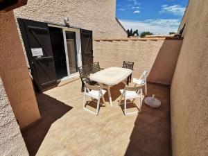 a patio with a table and chairs on a balcony at Résidence LES LEUCATINES 1 - Maisons & Villas pour 6 Personnes 24 in Port Leucate