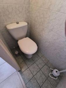 a bathroom with a white toilet in a tiled floor at Résidence LES LEUCATINES 1 - Maisons & Villas pour 6 Personnes 24 in Port Leucate
