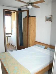 Schlafzimmer mit einem Bett und einem Deckenventilator in der Unterkunft Résidence MARINAS PORT ROSE 3 - 2 Pièces pour 6 Personnes 24 in Port Leucate