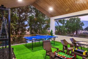 a patio with a ping pong table and chairs at EKOSTAY - Casa De Reva in Lonavala
