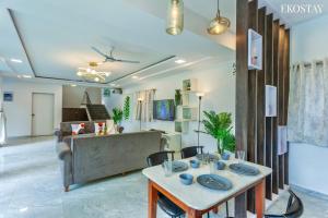 a living room with a table and a couch at EKOSTAY - Casa De Reva in Lonavala
