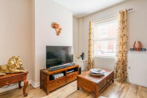 a living room with a television and a table at Protea Homestay in Manchester