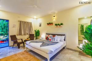 a bedroom with a bed and a desk and a chair at EKOSTAY - Casa De Reva in Lonavala +10 photos