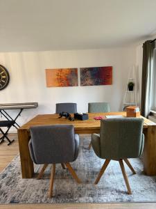 拉斯特德的住宿－Ruhige Wohnung in Nethen beim Beach Club，一间带木桌和椅子的用餐室