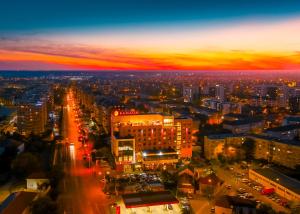 una vista aérea de una ciudad por la noche en Ramada by Wyndham Oradea, en Oradea