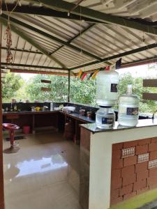 a large kitchen with a table and a counter at Farmhouse with Pool - Kalavady Farmstay in Baindūru