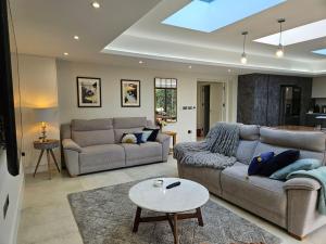 ein Wohnzimmer mit 2 Sofas und einem Tisch in der Unterkunft Homely 5 bed Cottage 30 mins to Heathrow, London, Legoland, Windsor Castle in Little Missenden