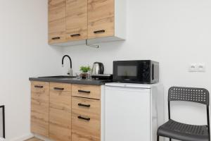 una cucina con forno a microonde e bancone con lavandino di Cozy Studio Batorego by Rent like home a Varsavia