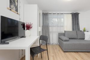 un soggiorno con scrivania bianca e divano di Cozy Studio Batorego by Rent like home a Varsavia