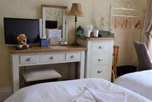 a bedroom with a desk with a tv and a bed at The View Guest House (Adults Only) in Llandudno