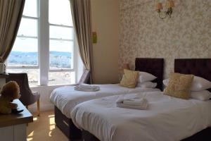 a hotel room with two beds with a window at The View Guest House (Adults Only) in Llandudno