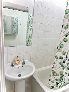 y baño con lavabo, espejo y bañera. en Beautiful One Bedroom Flat In Central London, en Londres
