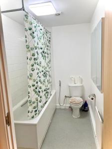 y baño con aseo y cortina de ducha. en Beautiful One Bedroom Flat In Central London, en Londres