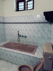 hello beach view resorts في فاركَالا: حمام مع حوض ومرحاض