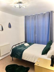 1 dormitorio con 1 cama y una ventana con cortinas azules en Beautiful One Bedroom Flat In Central London, en Londres
